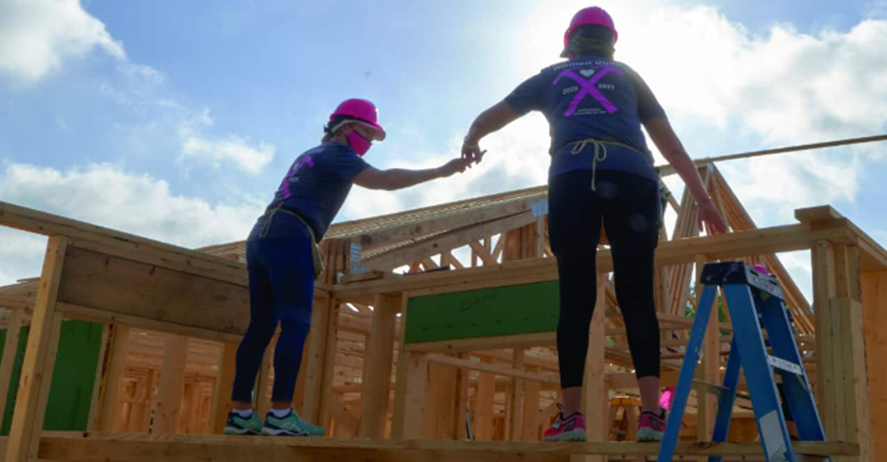 GAF team helping build a new home holding each other up.