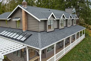 Beige home with a gray roof featuring new GAF Timberline UHDZ shingles.