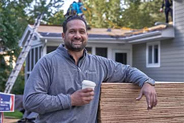 GAF Contractor outside home with new roof shingles being installed.