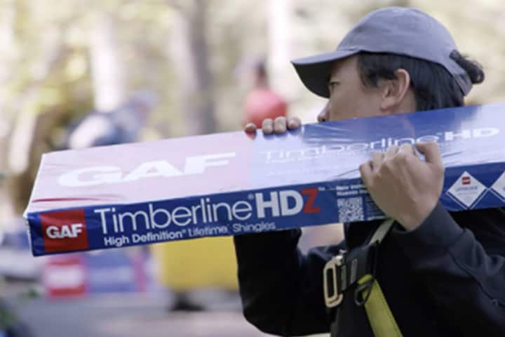 roofer carrying a package of Timberline HDZ