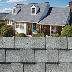 GAF Timberline HDZ fox hollow gray shingle closeup with sample product image on a brick house.