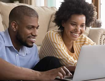 Man and woman looking at a laptop.