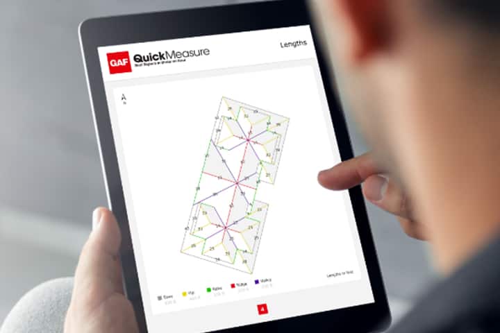 GAF certified contractor using GAF QuickMeasure, roof measurement tool, on a tablet.