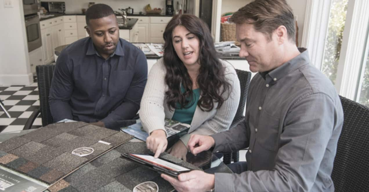 Man and woman reviewing roof restoration options with a certified GAF contractor.