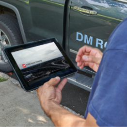 Man with tablet reviewing GAF roofing training documents